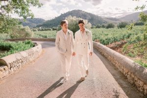 how to Survive the Heat on Your Wedding Day Adrian & Jack walking down the road at their destination wedding in Majorca