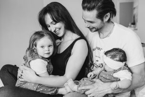 Hampshire Family photographer close up Black and white photo of Family sat on the bed looking at each other