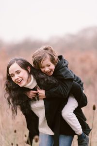 Hampshire Family photographer - Mother & son having a piggy back and a laugh together