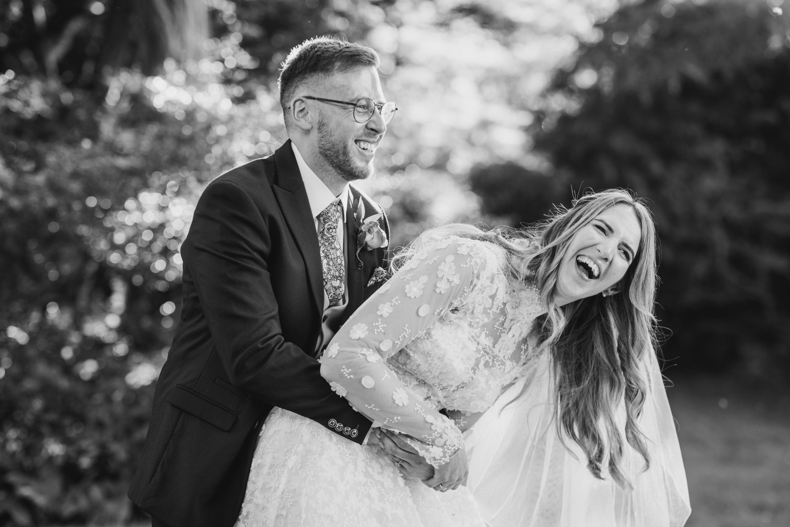 Black and White photo of Bride and groom having a cuddle and belly laughing together | Wedding Survival Kit