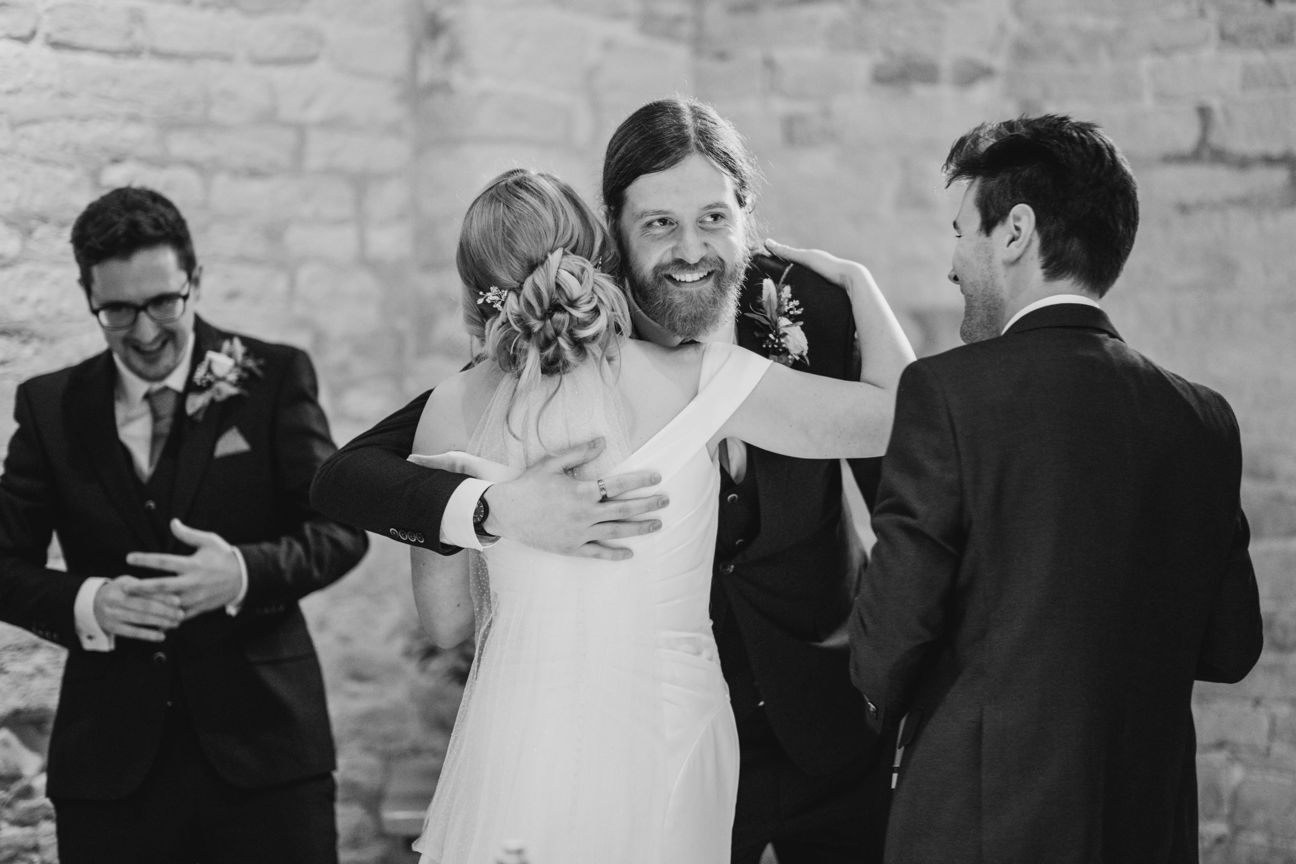 Groomsmen hugging bride after speech